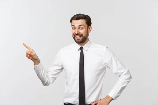 Joven hombre de negocios guapo apuntando a algo usando un dedo. Aislado sobre blanco —  Fotos de Stock