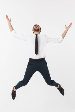 Beyaz arka planda izole edilmiş genç, mutlu beyaz iş adamı havaya atlıyor..
