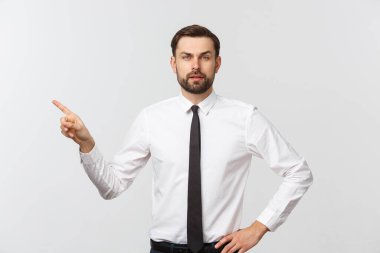 Sakallı ciddi iş adamı seni işaret ediyor. Gri stüdyo arka planında izole edilmiş.