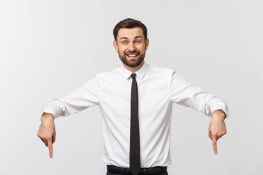 Genç yakışıklı iş adamı parmağını kullanarak bir şeyi işaret ediyor. Beyazda izole edilmiş