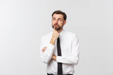 Düşünen adam beyaz arka planda izole edilmiş. Telif uzayına bakan genç ve düşünceli bir iş adamının yakın plan portresi. Beyaz erkek model.