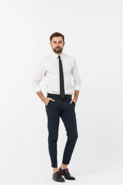 Beyaz arka planda elleri ceplerinde kendinden emin genç bir iş adamının portresi.