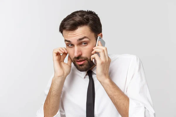 Enojado y serio hombre de negocios hablando por teléfono sobre fondo gris — Foto de Stock
