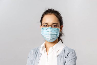 Covid19, virüs, sağlık ve tıp konsepti. Coronaviruts enfeksiyonunu önlemek için tıbbi yüz maskesi takan genç Asyalı kadın portresi karantina ve pandemi sırasında evde güvende kalmak...