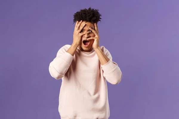 Retrato de chocado, assustado bonito homem sendo envergonhado e com medo de ver algo impróprio e estranho, olhos de cobertura, mas espreitando através dos dedos de interesse — Fotografia de Stock