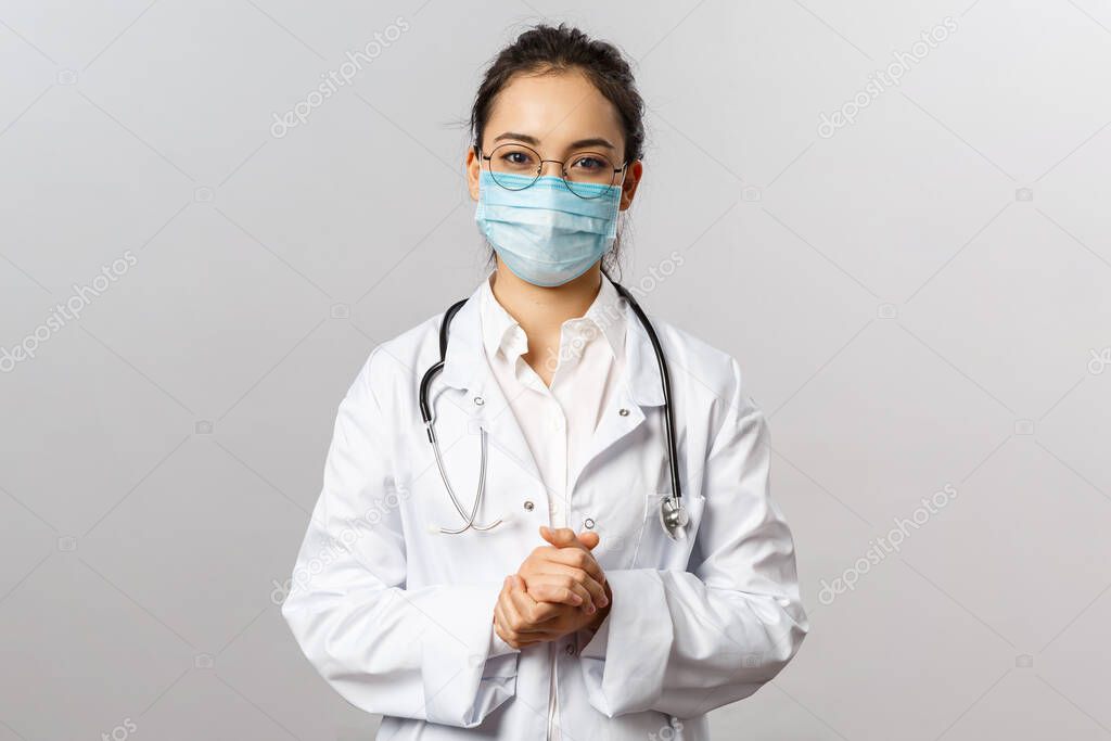 Covid19, coronavirus, healthcare and doctors concept. Portrait of asian doctor in medical mask and white coat, stethoscope, look after patients checking lungs, consulting how prevent caught virus