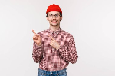 Belden yukarı portre komik ve rüya gibi bir adam gözlüklü ve kırmızı bereli, büyüleyici güzel manzara, üst sol köşeden memnun bir gülümseme gösteren, beyaz arka planda duran