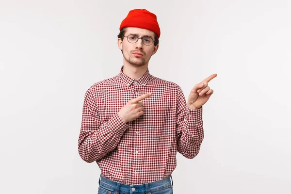 Portrait de taille jeune homme sceptique peu impressionné et ennuyé discuter dernière mise à jour de l'application avec expression triste mécontent, grimaçant avec désapprobation et manque d'intérêt, pointant coin supérieur droit — Photo