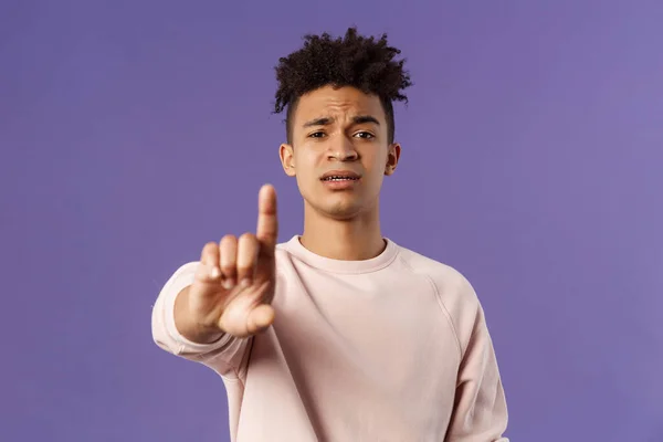 Close-up portrait of serious-looking hispanic man trying to prevent something bad, steping in for person being bullied, shaking index finger to scold wrong behavrious, forbid and prohibit something