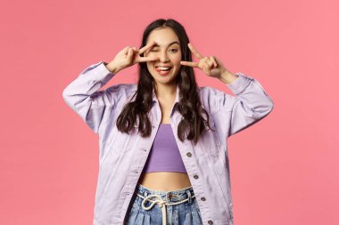 Sevgi ve barış insanları. Neşeli, kaygısız çekici kız pozitiflik ve mutluluk yolluyor, iyi niyet kawaii işareti yapıyor ve gülümsüyor, iyi bir ruh hali içinde, karantinanın sonunun keyfini çıkarıyor, pembe arka plan