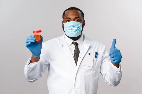 Covid19, 세계적 유행병 과 건강 관리 개념. 얼굴 마스크와 라텍스 장갑을 끼고 있는 아프리카 계 미국인 의사가 그 의 코로나 바이러스 검사 결과가 음성이라는 것을 확신시켜 주고 — 스톡 사진