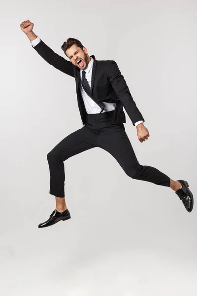Ritratto di un uomo d'affari felice che salta in aria su uno sfondo bianco isolato . — Foto Stock