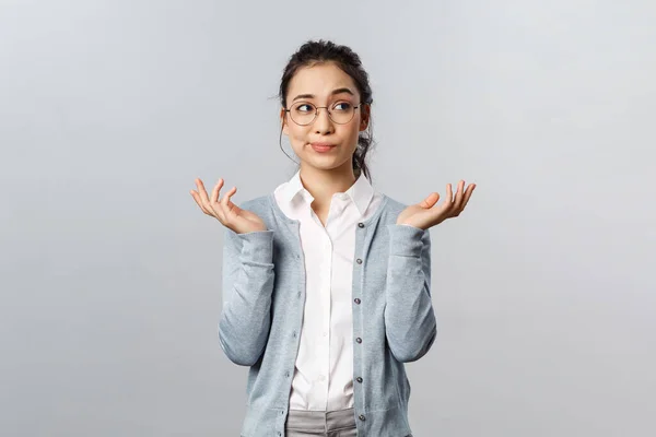 Style de vie, personnes et émotions concept. Qui sait ? Portrait d'indécis douteuse jeune femme asiatique brune, haussant les épaules regardant loin et souriant perplexe, hésitant incertain, ne peut pas dire, répondre à la question — Photo