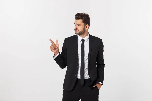 Porträt eines jungen Geschäftsmannes im Anzug, der auf Kopierraum vor weißem Hintergrund zeigt. — Stockfoto
