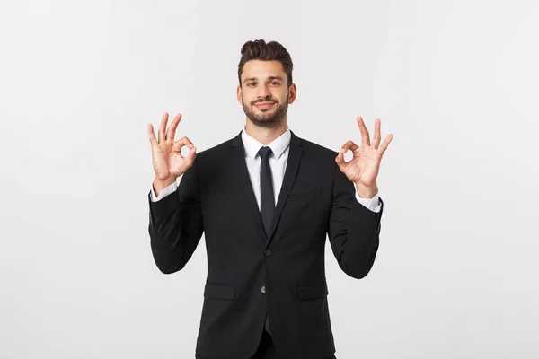 Schöner lächelnder Geschäftsmann zeigt Ok-Zeichen mit Fingern über grauem Hintergrund. — Stockfoto