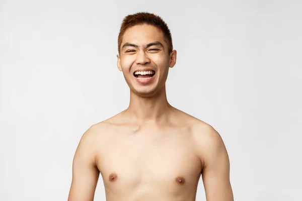 Krása, lidé a koncept domova. Detailní záběr portrét pohledného veselého asijského muže, hlasitě se smál, stál nahý a usmíval se potěšen, stojící bílé pozadí nadšeně — Stock fotografie