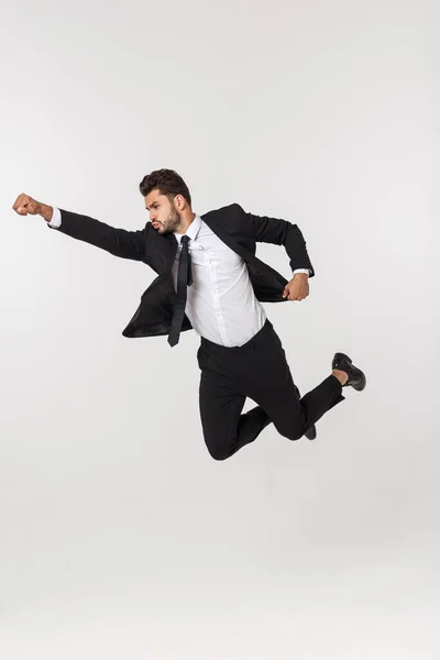 Fiatal boldog kaukázusi üzletember ugrál és repül a levegőben, elszigetelt fehér háttér — Stock Fotó
