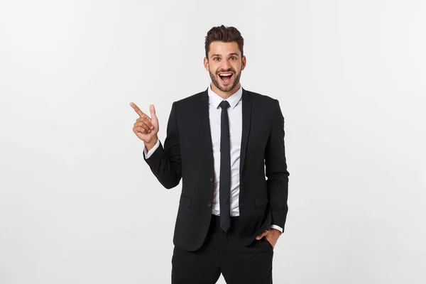 Porträt eines jungen Geschäftsmannes im Anzug, der auf Kopierraum vor weißem Hintergrund zeigt. — Stockfoto