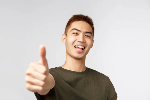 Pessoas, expressões diferentes e conceito de estilo de vida. Close-up retrato de otimista, alegrando-se asiático homem dizendo sim, mostrar thumb-up na aprovação, louvar bom trabalho, recomendo melhor qualidade, grande negócio — Fotografia de Stock