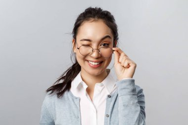 Reklam, insanlar ve duygu konsepti. Yüzsüz, sırıtan Asyalı esmer kadın garantisi. Bu ürünü seveceksiniz. Göz kırpan, cilveli ve gülümseyen.