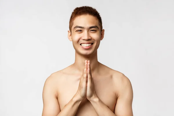 Beauty, people and home concept. Portrait of peaceful, relaxed asian man smiling happy, show namaste sign, praying or doing yoga, express gratitude, standing delighted white background — Stock Photo, Image