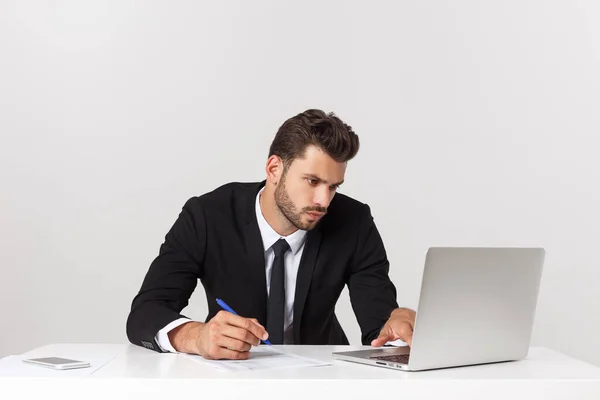 Seriöser gutaussehender Geschäftsmann, der im Büro arbeitet, Vorderansicht mit Laptop, isoliert auf weiß. — Stockfoto