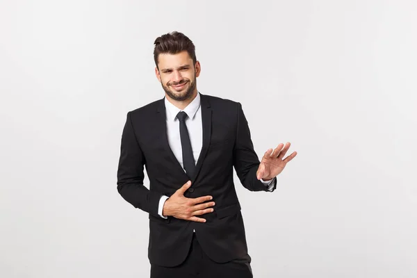 Unglücklicher Mann mit Magenschmerzen. Porträt eines gutaussehenden bärtigen Geschäftsmannes im Anzug. Indoor-Studioaufnahme, isoliert auf grauem Hintergrund — Stockfoto