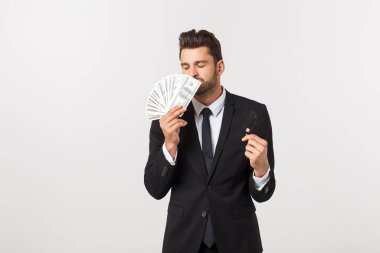 Elinde para dolu banknotlar ve beyaz arka planda izole edilmiş kredi kartı gösteren mutlu bir adamın portresi..