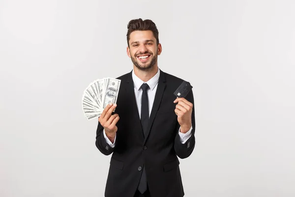 Retrato de un hombre feliz sonriente sosteniendo un montón de billetes de dinero y mostrando la tarjeta de crédito aislada sobre fondo blanco . — Foto de Stock