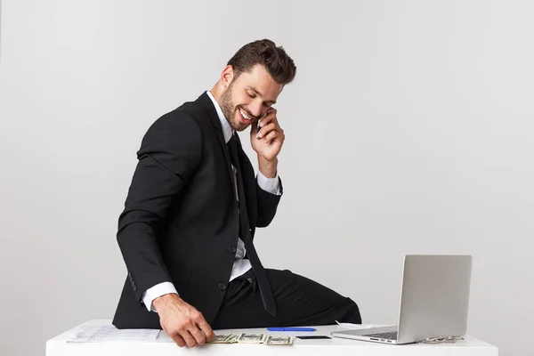 若いビジネスマンが職場で携帯電話と会話をしてる. — ストック写真