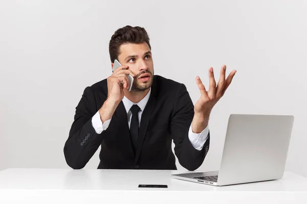 Caucásico atractivo hombre de negocios preocupado y cansado hablando en el teléfono móvil sentado en el escritorio de la oficina trabajando en el estrés sobrecargado de trabajo y frustrado . — Foto de Stock