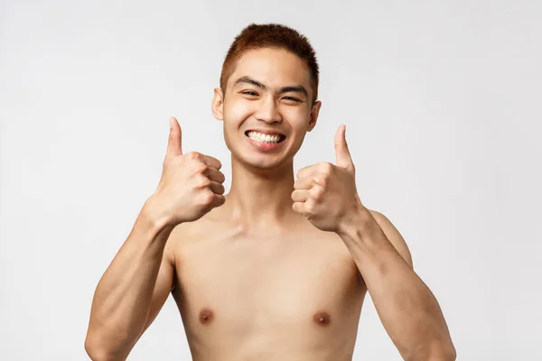 Beauty, people and home concept. Close-up portrait of satisfied, excited asian man standing naked, smiling upbeat, feel enthusiastic and rejoicing, standing white background, give approval — Stock Photo, Image