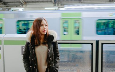 Japonya tren istasyonunda genç Asyalı kadın turist.