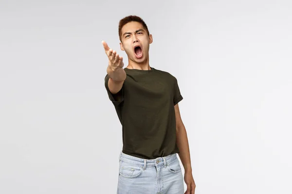 Portrait of pissed-off complaining, bothered asian man pointing with dismay at camera and accuse someone, look angry and outraged, blame person, judging bad behaviour, look at this mess — Stockfoto