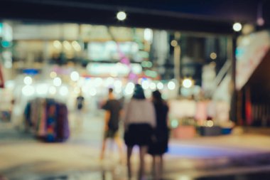 Soyut bulanık insanlar gece alışveriş merkezinde yürüyorlar.