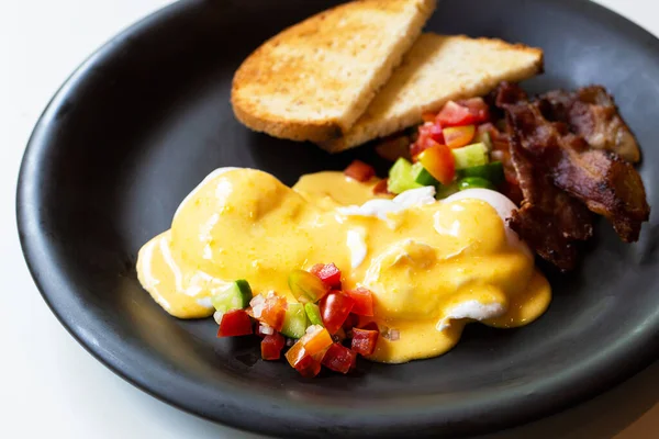 Uova Benedict - pane, becon e pomodoro, uova in camicia e deliziosa salsa olandese burrosa — Foto Stock