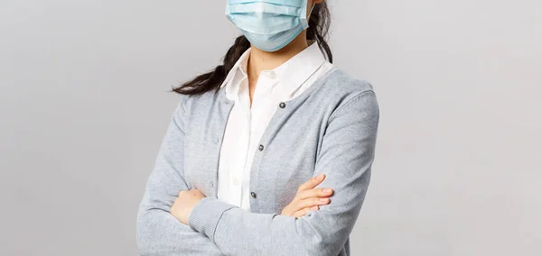 Covid19, Virus, Gesundheits- und Medizinkonzept. Porträt einer jungen selbstbewussten professionellen asiatischen Krankenschwester, die sich um Patienten kümmert, medizinische Maske während der Quarantäne trägt, Brust mit überkreuzten Händen — Stockfoto