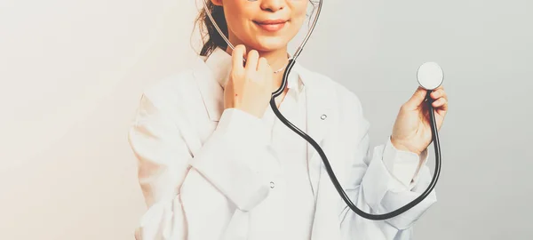 Covid19, koncepce koronaviru, zdravotní péče a lékařů. Portrét asijského lékaře, který naslouchá plícím pacienta, kontroluje zdravotní stav osob, nosí stetoskop a bílý plášť — Stock fotografie