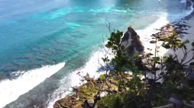 Güzel 4K tropikal plaj havası. Yukarıdan okyanus dalgalarının boş bir sahile çarptığı kuşbakışı bir manzara..