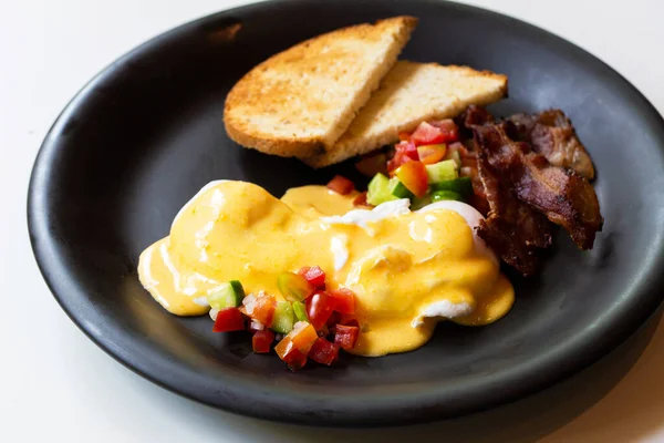 Uova Benedict - pane, becon e pomodoro, uova in camicia e deliziosa salsa olandese burrosa — Foto Stock