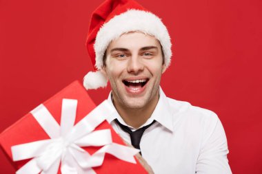Noel Konsepti - yakın plan Noel Baba iş adamı kırmızı arka planda kameraya kırmızı hediye veriyor.