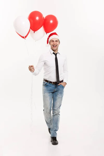 Julkoncept - Snygg glad Affärsman promenader med röd ballong fira god jul och gott nytt år bära Santa hatt. — Stockfoto