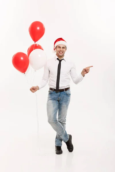 Рождество - счастливый бизнесмен, гуляющий с красным воздушным шаром, празднует веселые праздники и счастливый Новый год в шляпе Санта-Клауса . — стоковое фото