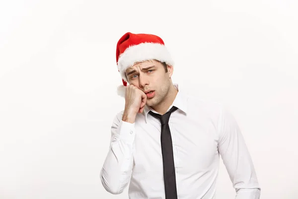 Conceito de Natal - Bonito homem de negócios usar chapéu de Papai Noel posando com expressão facial estressante em fundo isolado branco . — Fotografia de Stock