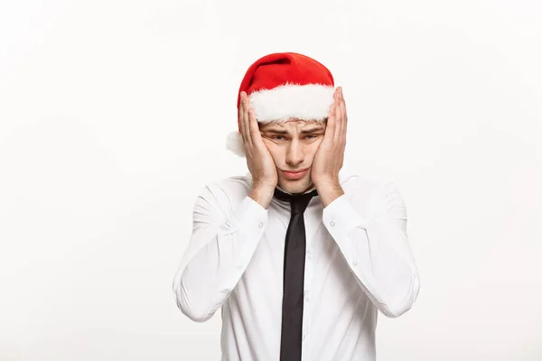 Kerst Concept - Handsome Business man dragen santa hoed poseren met stressvolle gezichtsuitdrukking op witte geïsoleerde achtergrond. — Stockfoto
