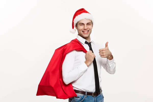 Conceito de Natal - Bonito homem de negócios comemorar Feliz Natal e feliz ano novo usar chapéu de Papai Noel com saco grande vermelho . — Fotografia de Stock