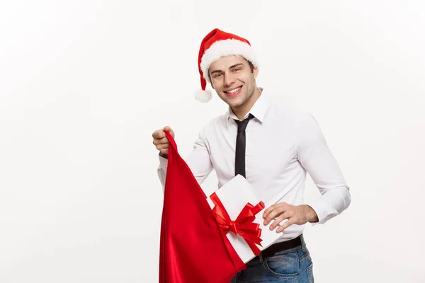 Weihnachts-Konzept - Schöner Geschäftsmann feiern frohe Weihnachten und ein glückliches neues Jahr tragen Weihnachtsmütze mit Santa roten Big Bag. — Stockfoto