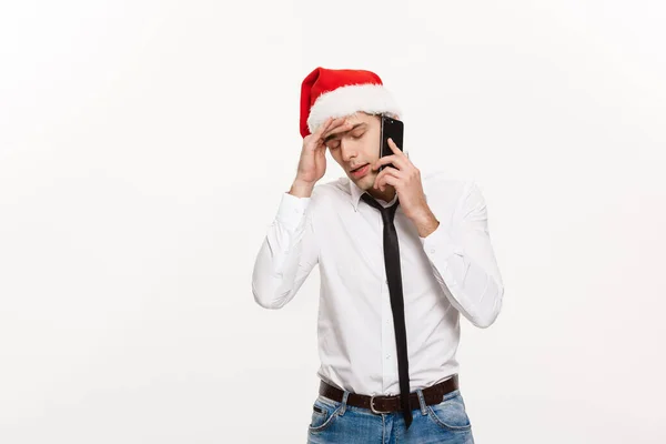 Vánoční koncepce - stresující pohledný podnikatel vážně mluvit po telefonu na Štědrý den. — Stock fotografie