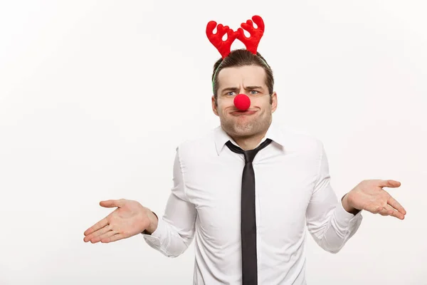 Christmas Concept - Hombre de negocios guapo que usa diadema de reno haciendo expresión facial divertida . — Foto de Stock