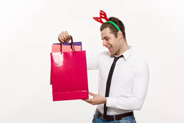 Weihnachts-Konzept - Schöner Geschäftsmann feiern frohe Weihnachten und ein glückliches neues Jahr tragen Rentier Haarband und halten Santa roten Big Bag. — Stockfoto